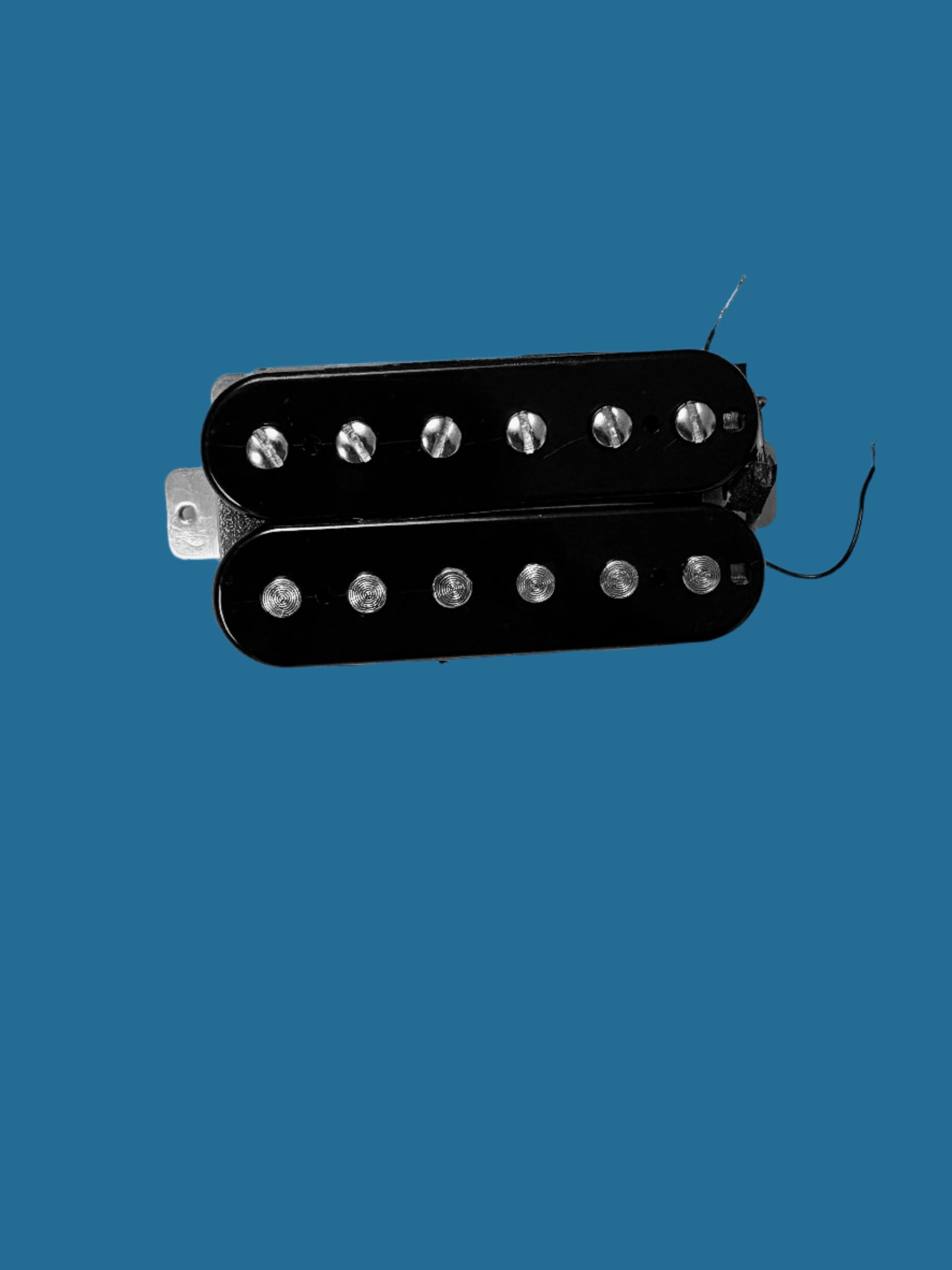 A black PAF-style humbucker guitar pickup with visible wire wound around a pole, set against a blue background.